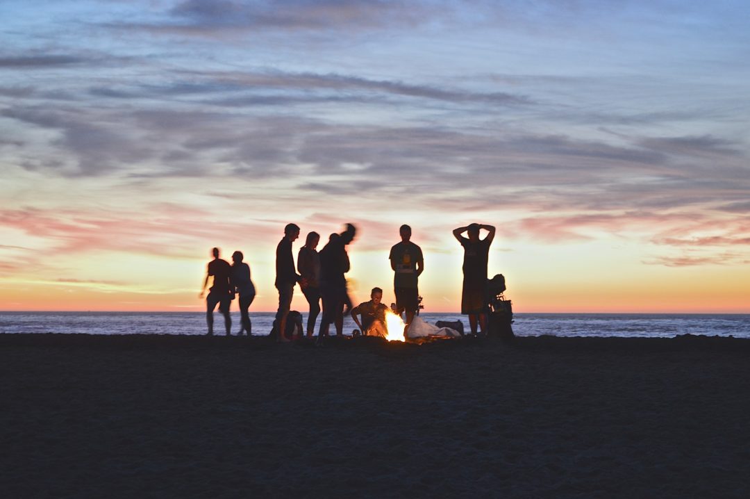 people by beach campfire