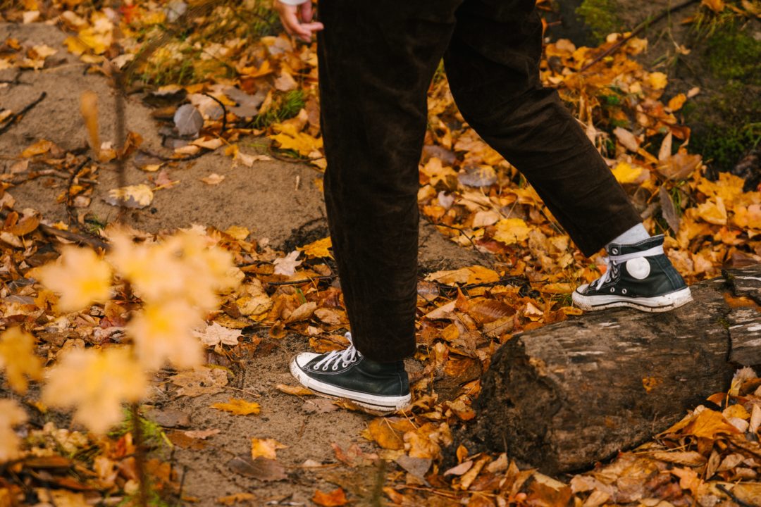 person walking in fall leaves