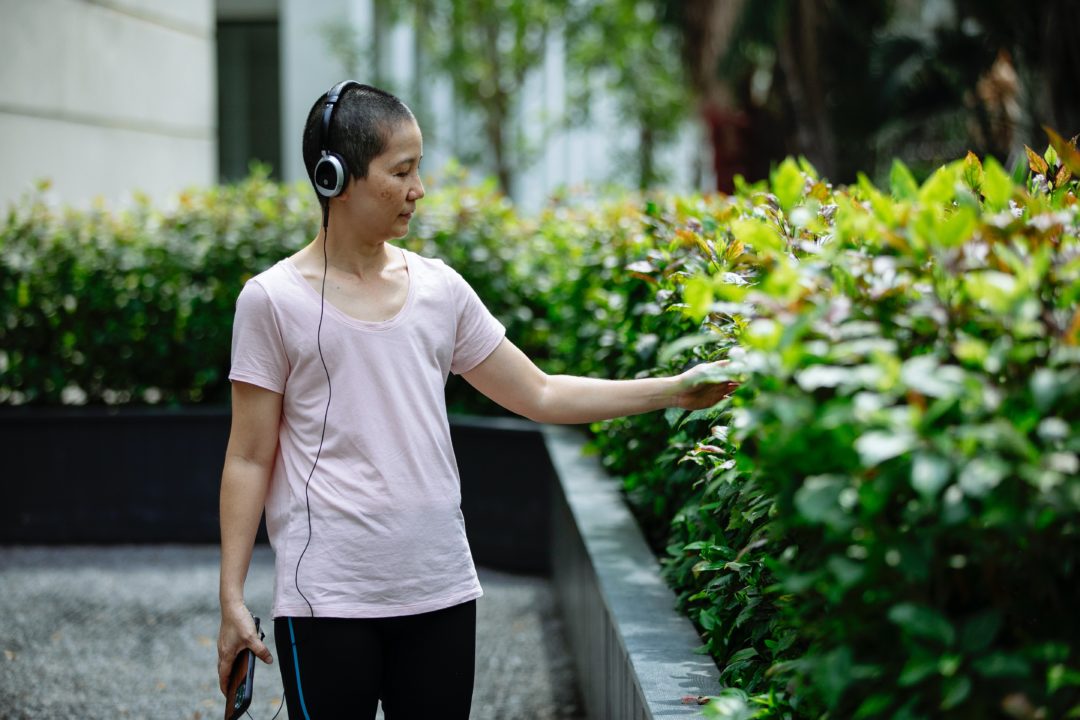 Woman listening to earbuds outside