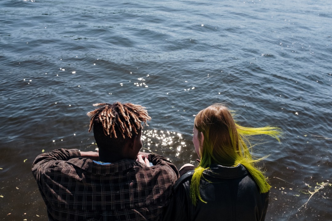 Two friends sitting by the water together