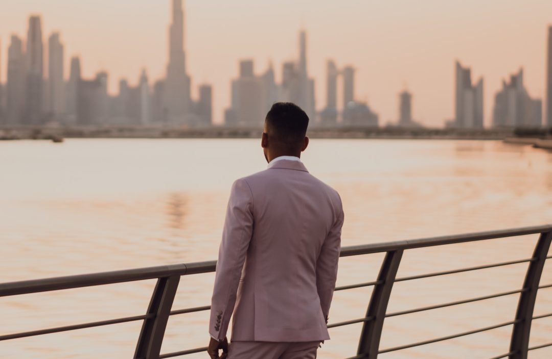 man in a suit looking at city skyline