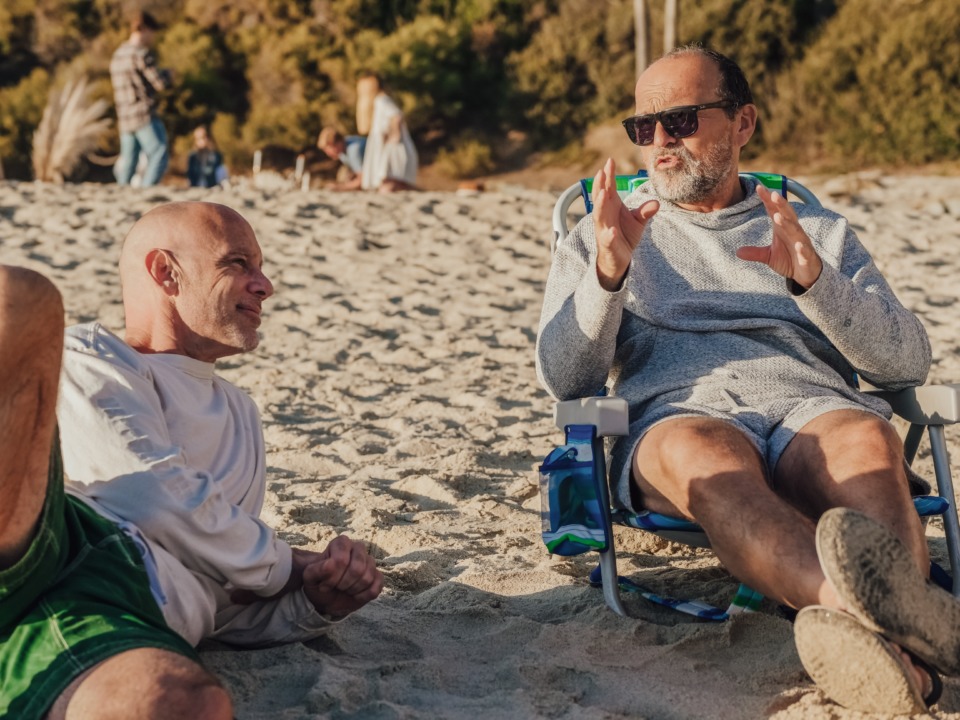 two men talking on the beach