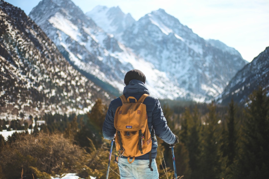 Man looking out at snowy mountains