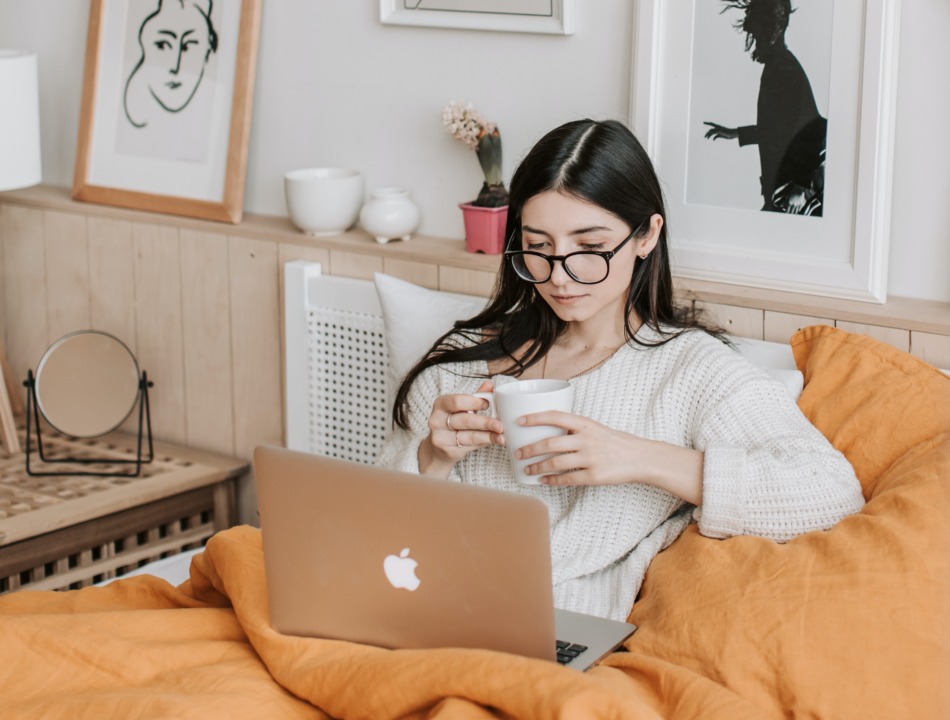 Woman sitting on couch with computer and coffee