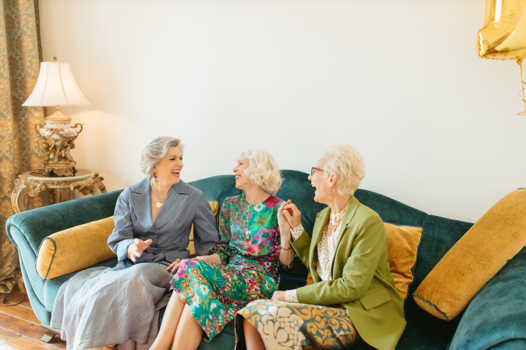 Older women laughing together on a couch