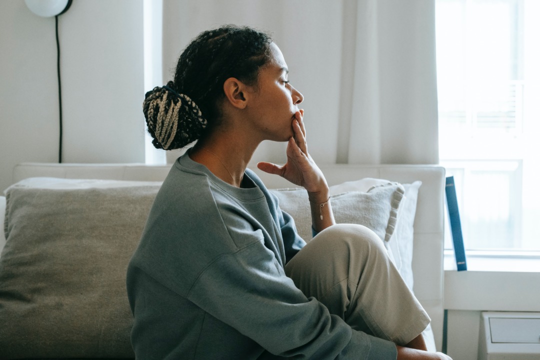 Woman sitting and thinking in her living room