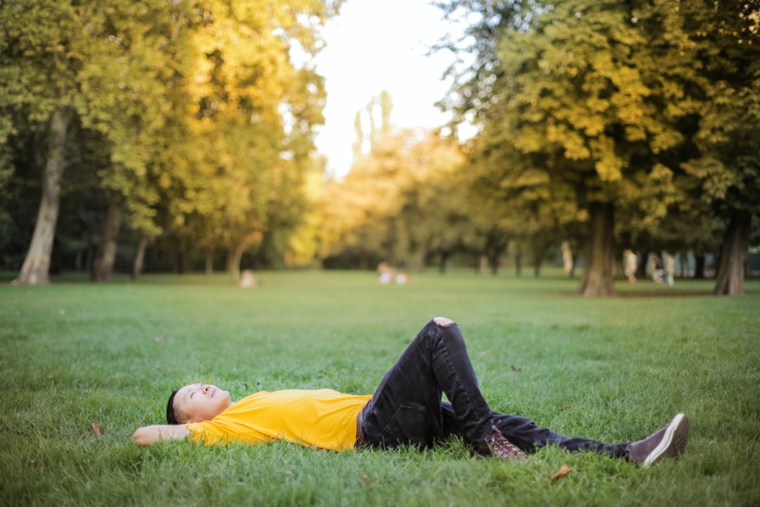 man laying in grass thinking
