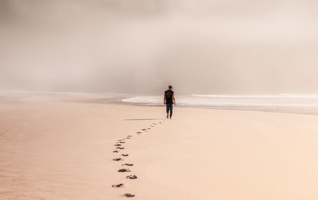 Person walking on beach in fog