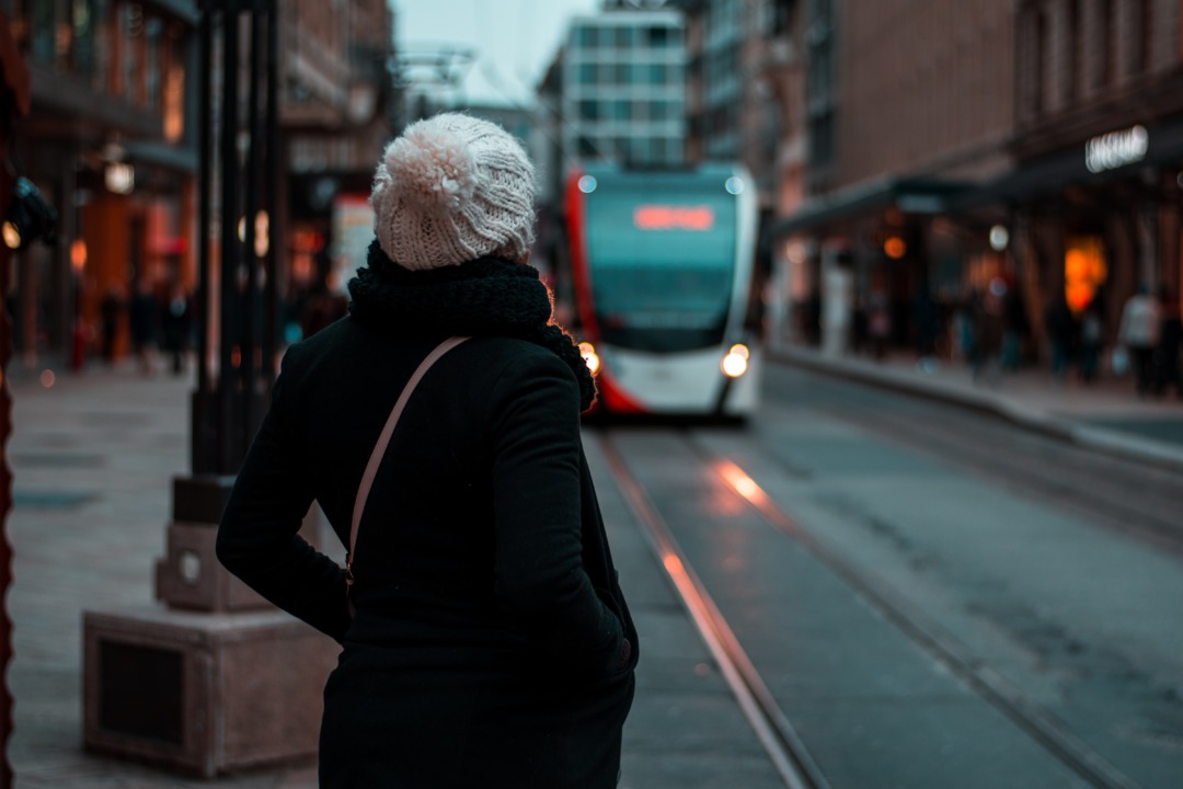 Woman waiting for the bus in a city at night