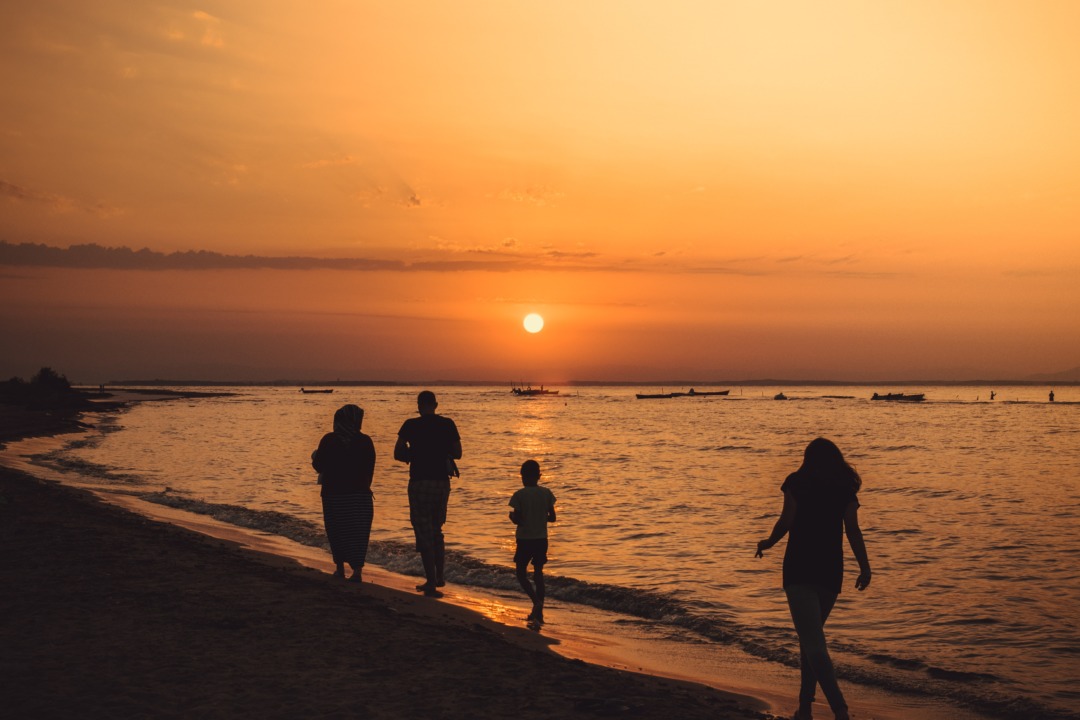 Family on the beach at sunset