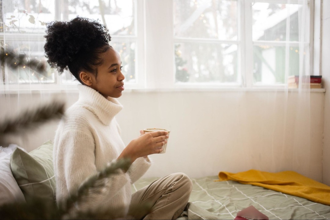 Woman sitting in bed with a cup of tea