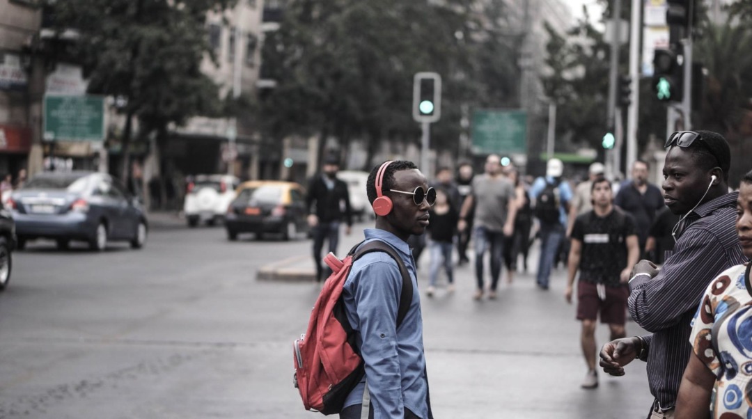 man on street with headphones and sunglasses