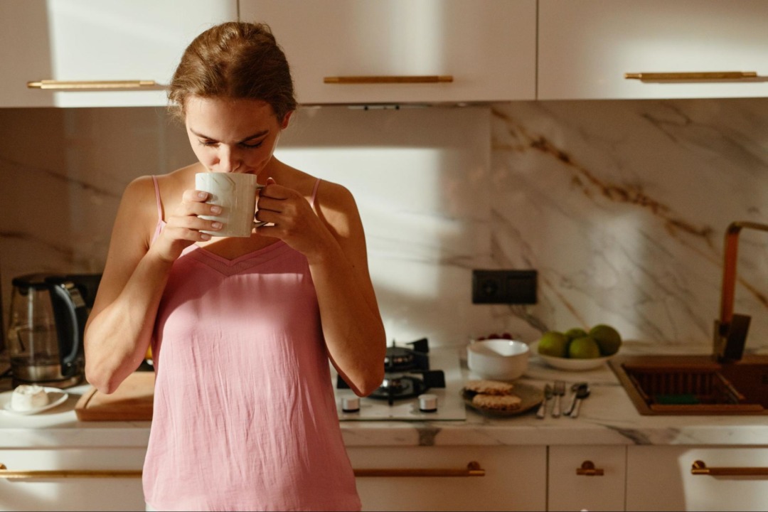 woman drinking coffee in the kitchen