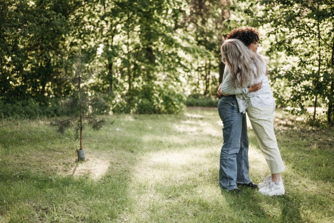Lesbian couple hugging in backyard