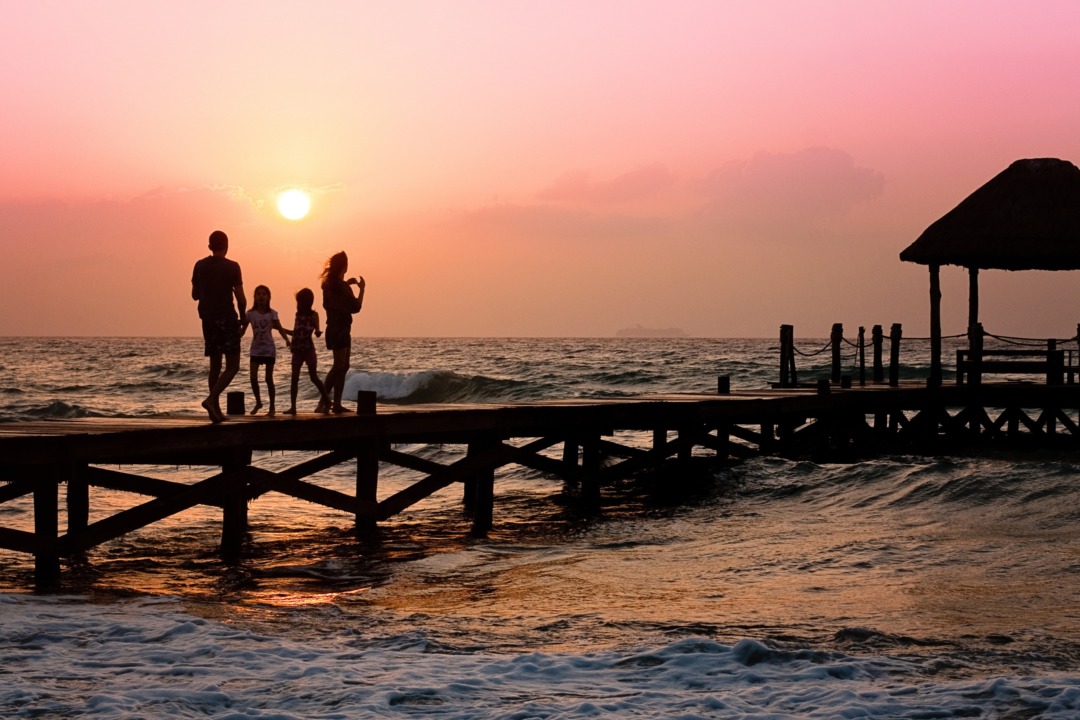 family watching sunset from pier