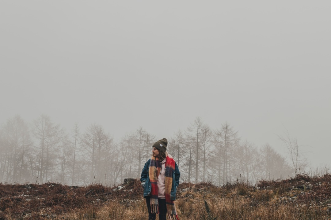 Person standing in front of foggy forest