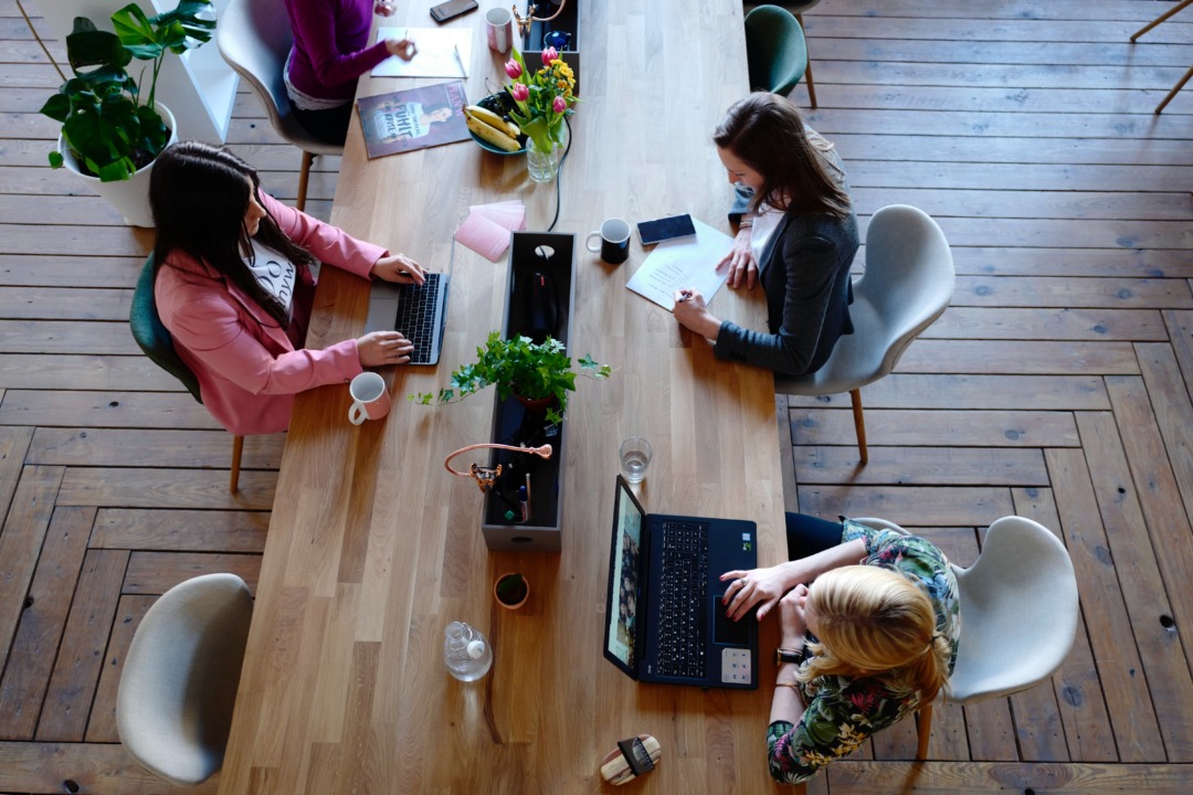 Women working at a table together with flowers