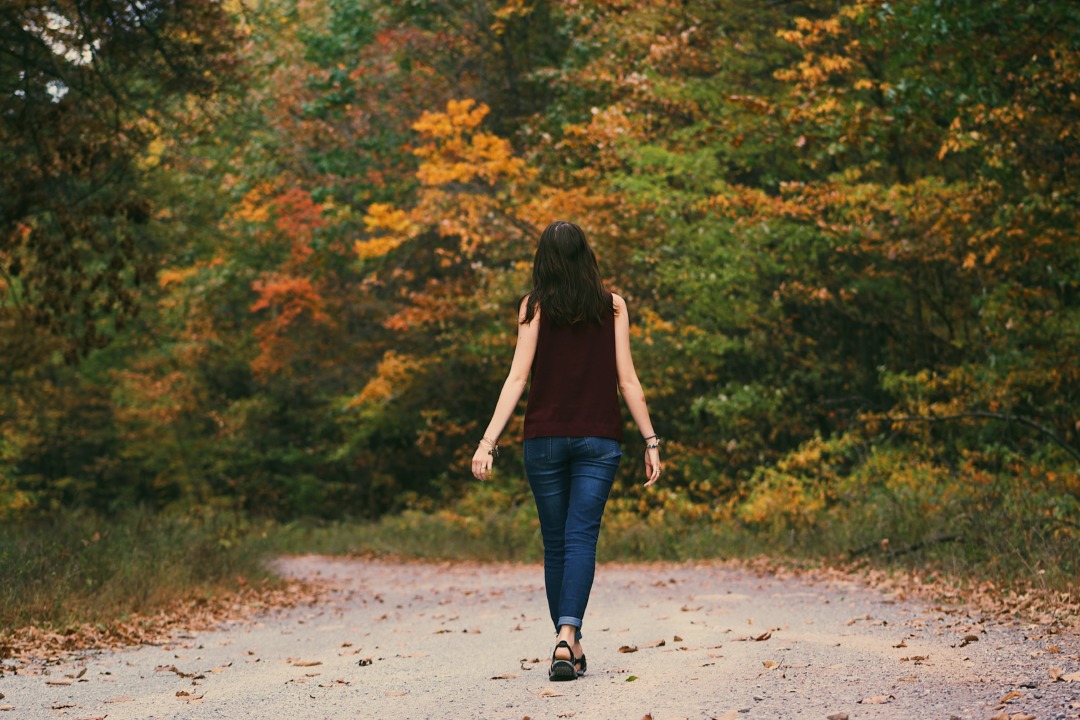 Woman walking down a path in fall