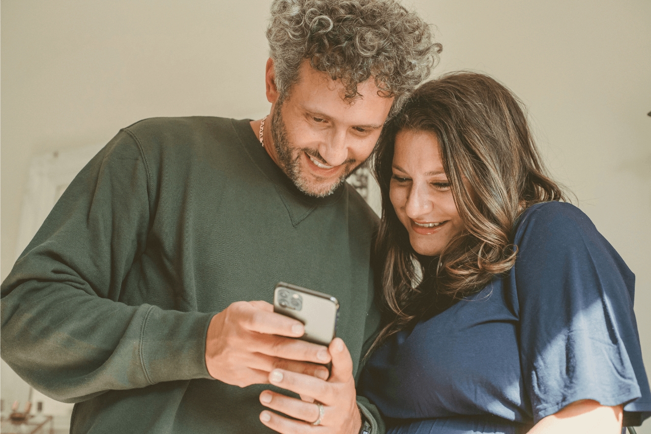 Couple smiling at phone