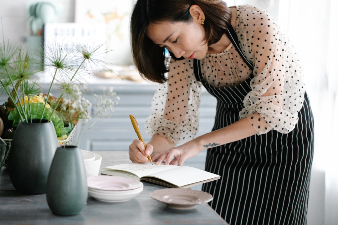woman in an apron making notes in the kitchen